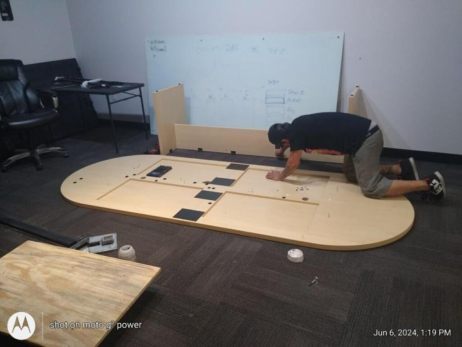 In or Out Movers crew assembling a conference table during an office move