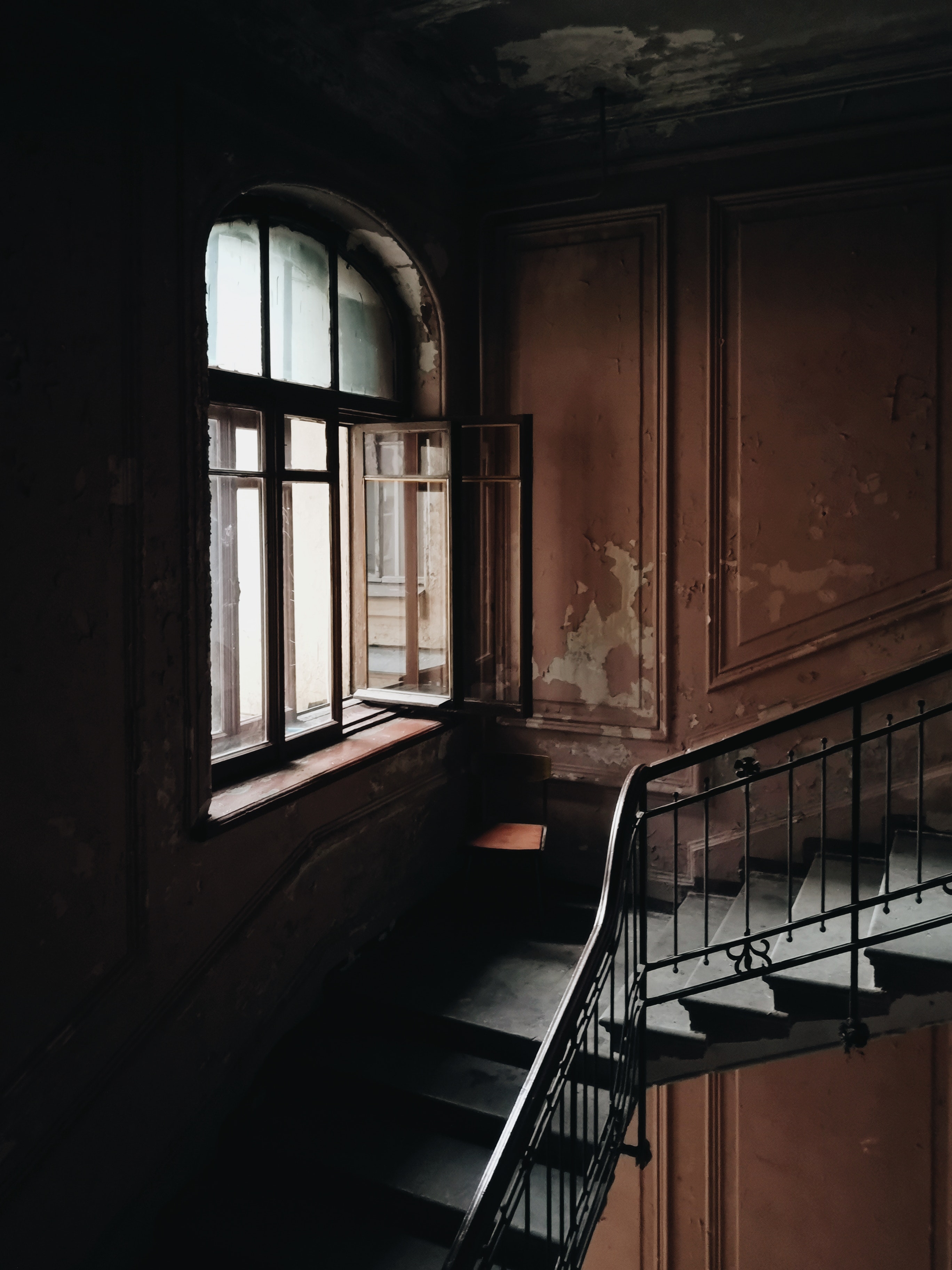 Dark ominous stairwell with natural light peering through the window